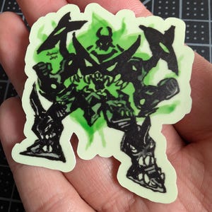May include: Black and green sticker featuring a cartoon monster with sharp teeth and horns. The monster is surrounded by a green glow. The sticker says "animal days" in the bottom left corner.