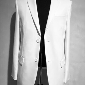 May include: A white blazer with a single button closure and two pockets. The blazer is on a black mannequin.
