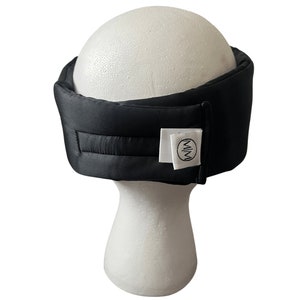 May include: Black sleep mask with a white label that says "MIM" on it.