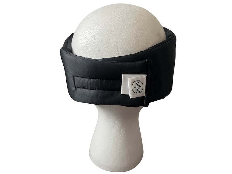 May include: Black sleep mask with a white label that says "MIM" on it.