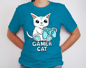 May include: A turquoise blue t-shirt with a white cat holding a blue video game controller. The text "Gamer Cat" is printed below the cat.