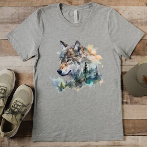 May include: A gray t-shirt with a watercolor design of a wolf's head with a forest background.