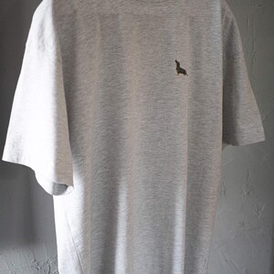 May include: A heather grey t-shirt with a small embroidered dachshund on the front.