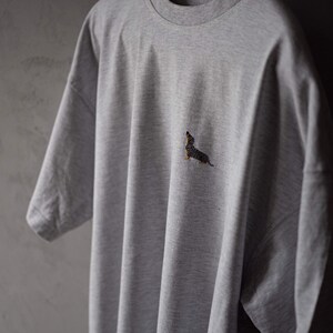 May include: A gray t-shirt with a small embroidered dachshund on the front.