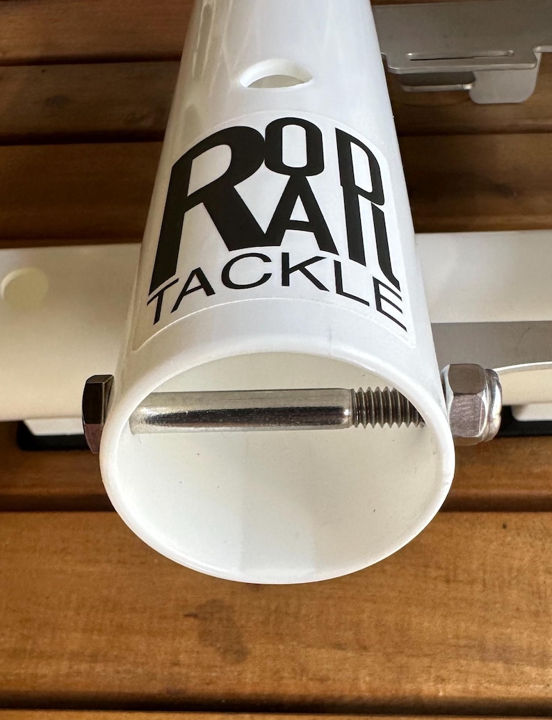 May include: White plastic rod holder with a silver metal screw and nut. The holder has a black logo that says "Rod Rail Tackle".