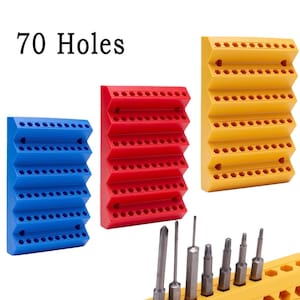 May include: Three colorful bit holders in blue, red, and yellow, each with multiple holes for storing bits. The text "70 Holes" is displayed above the holders. Several metal bits are placed in the yellow holder.