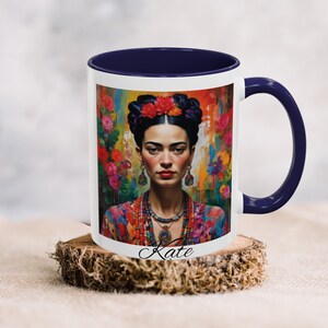 May include: White ceramic mug with a blue rim and handle. The mug features a colorful image of a woman with a flower crown and colorful jewelry. The text "Kate" is printed on the bottom of the mug.