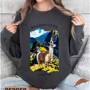 May include: Dark gray sweatshirt featuring a colorful graphic of a llama in front of Machu Picchu. The text "MACHUPICCHU" and "CUZCO-PERÚ" are printed above and below the graphic. The word "PEPPER" is printed at the bottom.