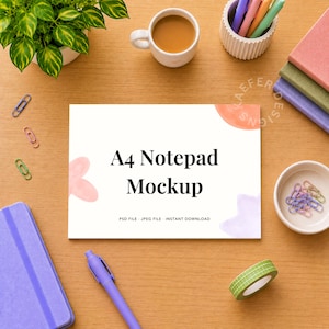 May include: An A4 notepad mockup with the text "A4 Notepad Mockup" on a wooden surface. The image includes a cup of coffee, pens, notebooks, and stationery items. The notepad has a floral design.