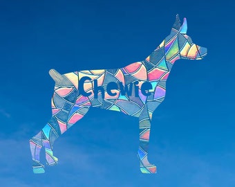 Peut inclure: Une silhouette de chien en verre coloré sur un fond de ciel bleu. Le nom du chien, "Chewie", est écrit dans la silhouette.