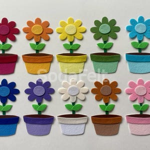 May include: A collection of colorful felt flower pot decorations. Each flower has a different color, including red, orange, yellow, green, blue, purple, white, brown, and pink. The pots are also in various colors, with green leaves and brown soil.