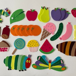 May include: Felt craft pieces depicting the story of The Very Hungry Caterpillar. The pieces include a green caterpillar, a red apple, a green leaf, a slice of watermelon, a cupcake, a lollipop, a piece of cake, a sausage, a slice of pie, a piece of cheese, a cucumber, a banana, a butterfly, and a brown cocoon.
