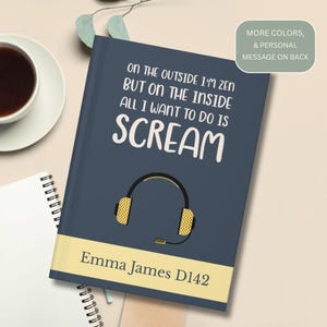 May include: A navy blue journal with the text "ON THE OUTSIDE I'M ZEN BUT ON THE INSIDE ALL I WANT TO DO IS SCREAM" in white. A yellow headset graphic is below the text. The bottom of the journal has the text "Emma James D142" in white on a yellow background.