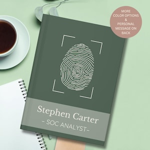 May include: A white ceramic mug with a black handle and the text "But First, Coffee" in a black, handwritten-style font. The mug is on a white surface.