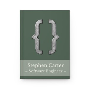 May include: A hardback notebook with a dark green cover. The cover features a silver bracket symbol and the text "Stephen Carter - Software Engineer" in white. A professional and stylish notebook.