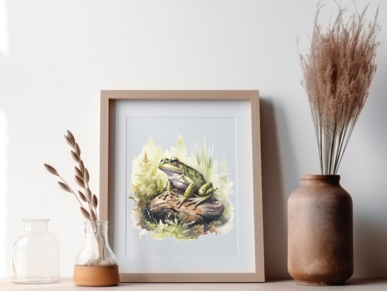 Puede incluir: Una pintura de acuarela de una rana verde sentada en una roca en un entorno de bosque. La rana tiene un cuerpo verde claro con manchas verde oscuro y una roca marr&oacute;n claro.
