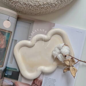 May include: A white ceramic tray with a unique, organic shape. The tray is sitting on a magazine with the text "Mayalavana Art Studio" and "Aesthetic Sustainable Home Decor".