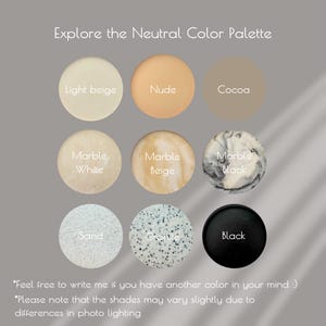 May include: A neutral color palette with nine different shades of beige, brown, white, black, and gray. The colors are arranged in a grid with the names of each color listed below the corresponding color swatch.