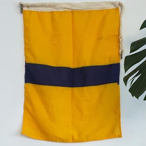 Bandera náutica vintage de Nueva Zelanda: bandera de señales, amarilla con franja azul.