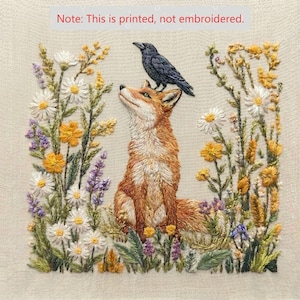 May include: A printed fabric panel featuring a fox sitting among wildflowers with a black crow perched on its head. The design includes white daisies, yellow blossoms, and purple sprigs on a beige background. Text reads: Note: This is printed, not embroidered.