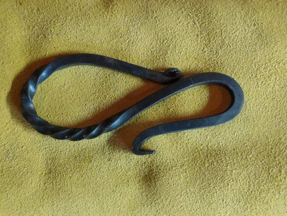 A blacksmith actually hammered this bottle opener out of raw iron — you can see the forge marks, and no two are alike.