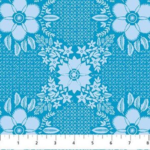 May include: A close-up of a blue and white floral fabric with a repeating pattern. The design features large stylized flowers and intricate details. The fabric is measured with an 8-inch ruler.