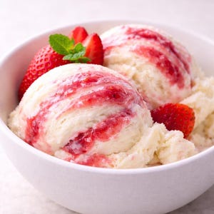 May include: A white bowl filled with two scoops of vanilla ice cream swirled with red strawberry sauce. Fresh strawberries and mint leaves garnish the dessert, creating a refreshing and colorful treat.