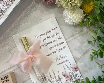 Perfume en spray con tarjeta decorada con flores y frase personalizada.