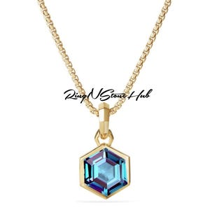 May include: A gold chain necklace with a hexagonal pendant featuring a blue gemstone.