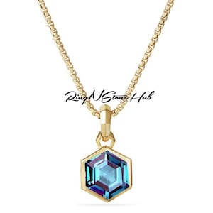 May include: A gold chain necklace with a hexagonal pendant featuring a blue gemstone.