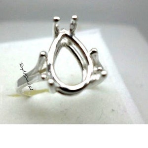 May include: Silver ring setting with a pear-shaped bezel for a gemstone.