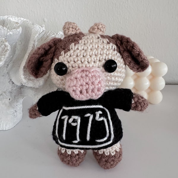 The 1975 Kuh Cow wearing a sweater crochet cuddly toy