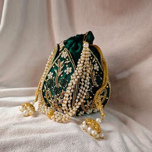 The green potli bag with its drawstring loosened, revealing the interior space of this beaded potli bag.