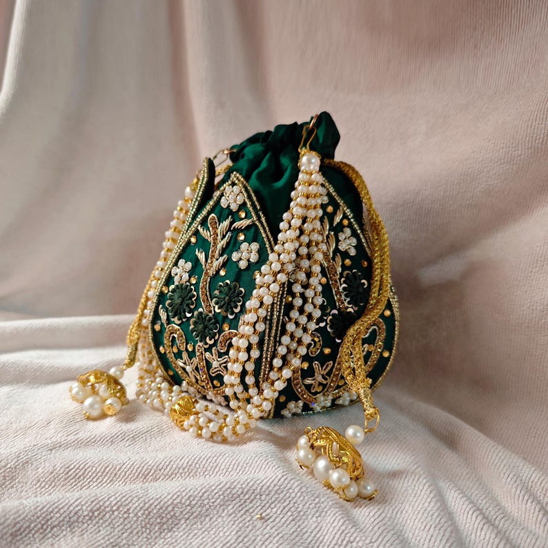 The green potli bag with its drawstring loosened, revealing the interior space of this beaded potli bag.