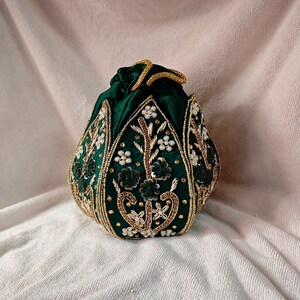 Close-up view of the intricate Zardozi threadwork on the green lotus motif of this Indian bridal purse.