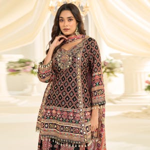 Detailed shot focusing on the handcrafted Aari work motifs on the silk fabric.