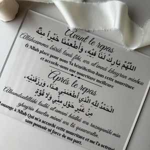 Może przedstawiać: Biały znak akrylowy z czarnym tekstem w języku arabskim i francuskim. Tekst brzmi "Avant le repas" i "Aprés le repas" z modlitwą w języku arabskim.