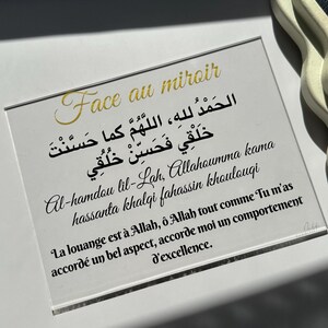 May include: A framed print with gold text that reads "Face au miroir" and a prayer in Arabic and French. The print is on a white background.