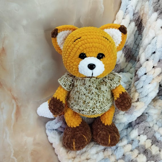 かぎ針編みのぬいぐるみのキツネの子。手作りのキツネ。ブラウスは