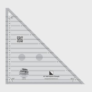 May include: A clear, triangular quilting ruler with black markings and measurements in inches. The ruler has a 45-degree angle and is labeled "45° Half-Square Triangle" and "Creative Grids".