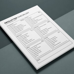 May include: A black and white checklist with the title "Declutter Checklist" and the subtitle "Less mess, less stress". The checklist is divided into sections for different rooms of a house, including the living room, bathroom, bedroom, office, and garage. Each section has a list of items to declutter.