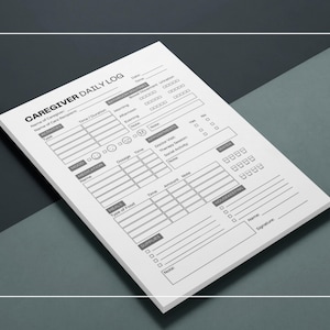 Op de afbeelding: Een witte Caregiver Daily Log notitieblok met zwarte tekst. Het logboek bevat secties voor activiteiten, stemming, medicatie, maaltijden en huishouding. Het notitieblok staat schuin op een donkergrijze en zwarte ondergrond.