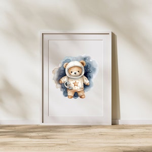 May include: A watercolor illustration of a brown teddy bear wearing an astronaut suit with a star on the chest. The bear is standing in a blue and white watercolor galaxy background.