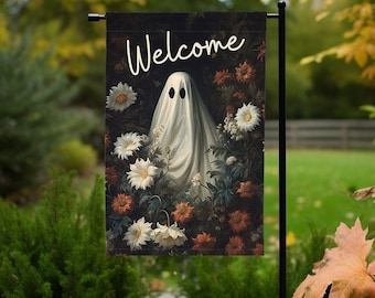 May include: A Halloween-themed welcome flag with a white ghost with two black eyes standing in a field of flowers. The flag has a black background and the word "Welcome" written in white.