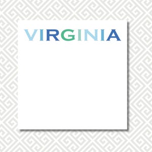 May include: White notepad with the word "VIRGINIA" in blue and green letters. The notepad is centered on a light gray patterned background.