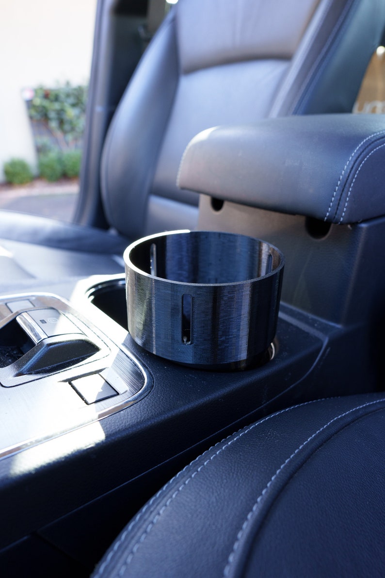 This is our new V2 Cup Holder adaptor for Frank Green 1000ml drink bottles and the YETI Rambler 36oz drink bottles. The slotted holes in the side reduce suction so you don't have the adaptor come out with the bottle when you want a drink.