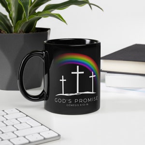 May include: Black coffee mug with a rainbow and three white crosses. The text "God's Promise Genesis 9:13-16" is printed on the mug.