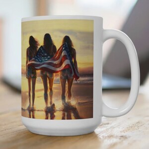 Op de afbeelding: Drie vrouwen die bij zonsondergang over een strand lopen, met een Amerikaanse vlag in hun handen. De vlag wappert achter hen in de wind. De vrouwen dragen shorts en tanktops. Het strand is zanderig en het water is blauw.