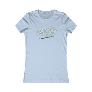 Può includere: T-shirt azzurra con la scritta "Blaskia Original Made in Norway" in corsivo. Il testo è di colore giallo chiaro con dettagli a stella. La maglietta ha maniche corte e scollo tondo.