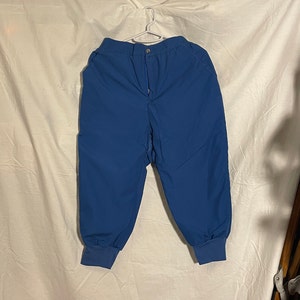 May include: A pair of blue, casual pants with a drawstring waist and elastic cuffs. The pants are made of a lightweight, breathable fabric.
